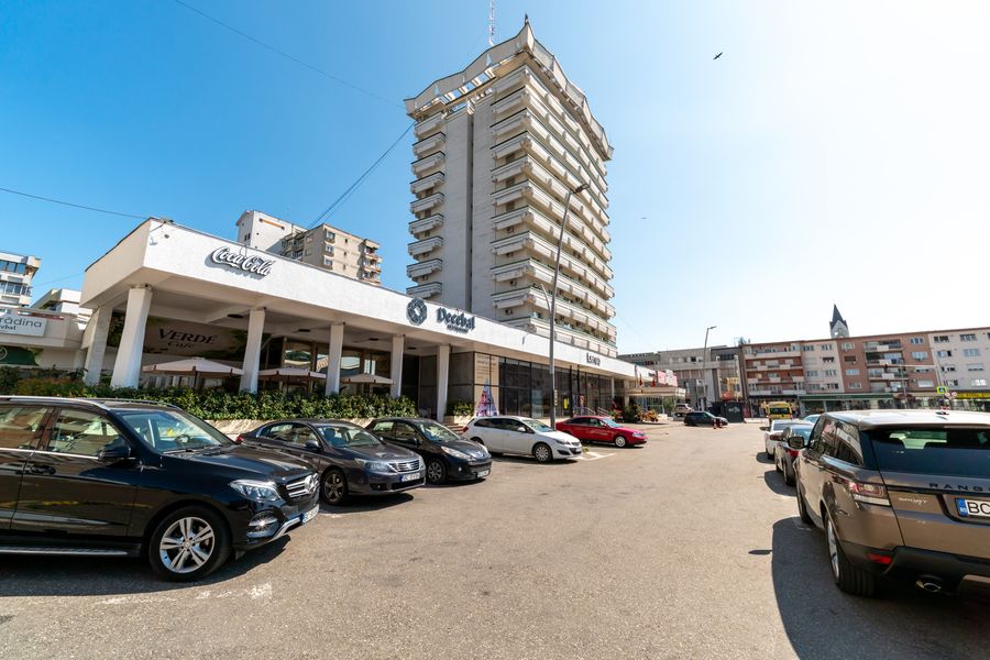Parcare cu hotelul în fundal în parcarea Hotelului Decebal din Bacău