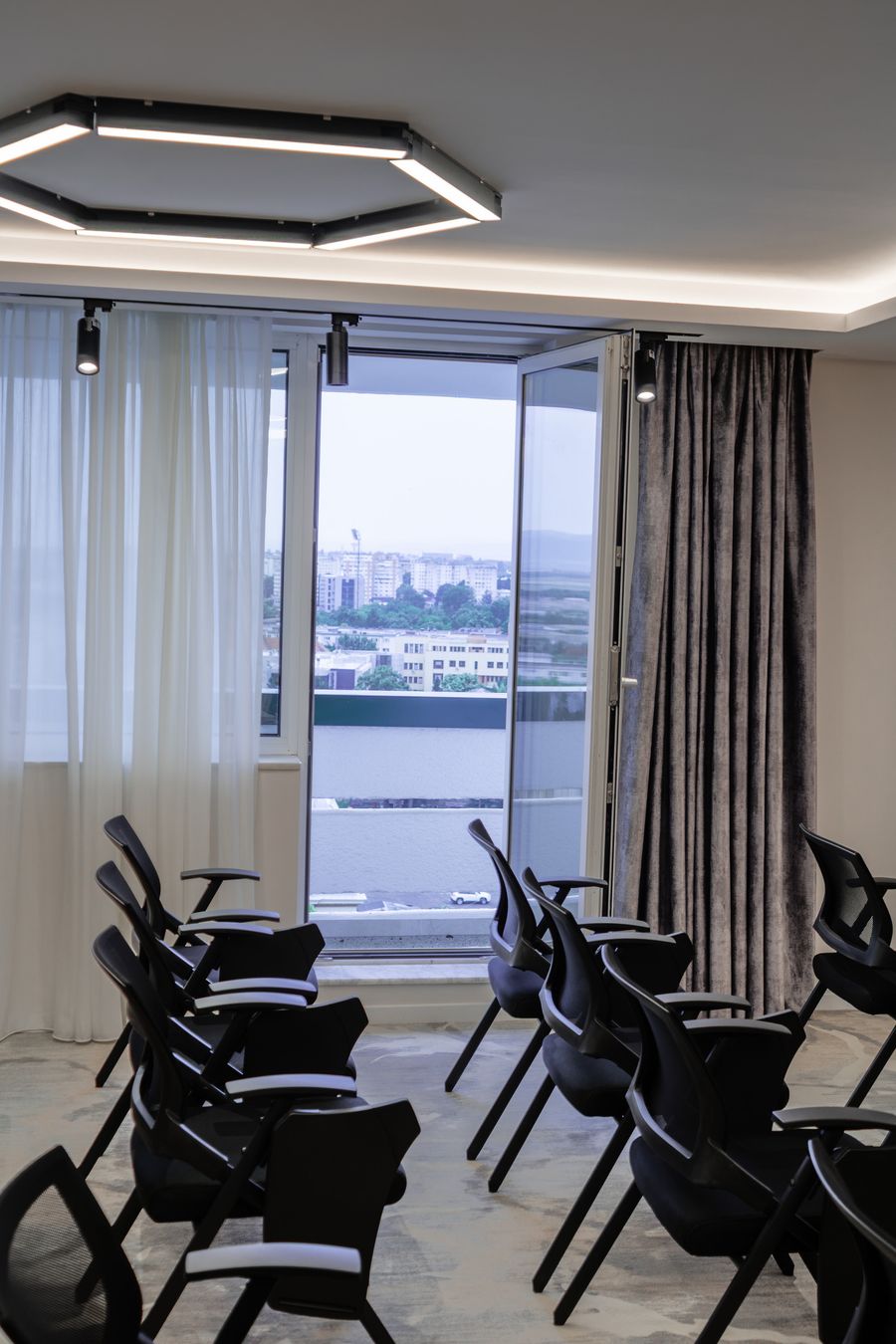 Sala de conferințe cu lumină naturală și ferestre ample la Hotel Decebal din Bacău